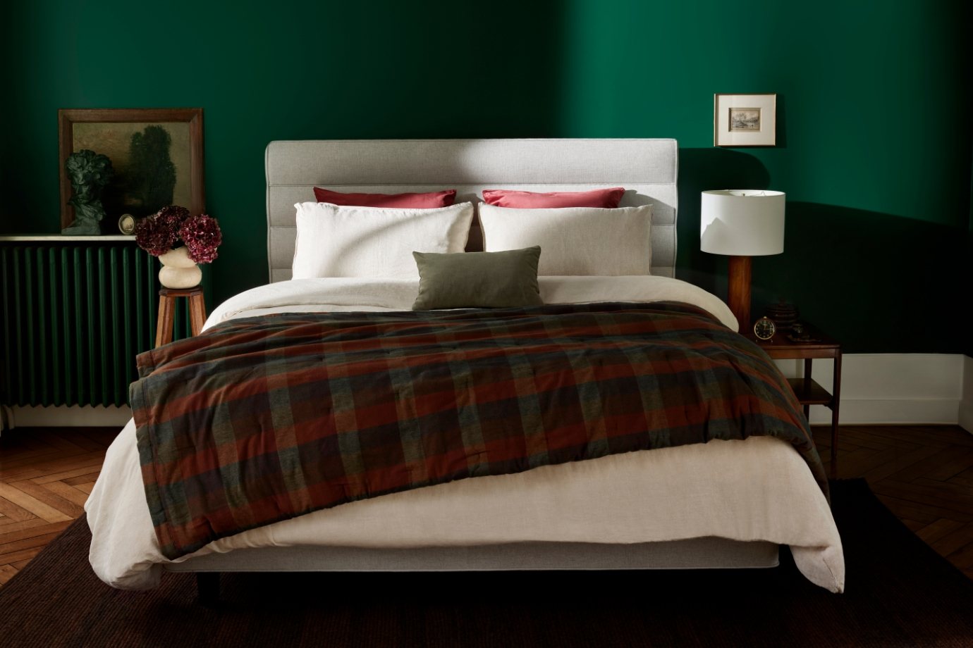Luxury Vispring bed in a green bedroom with contrast headboard and tartan quilt, classic vintage interiors